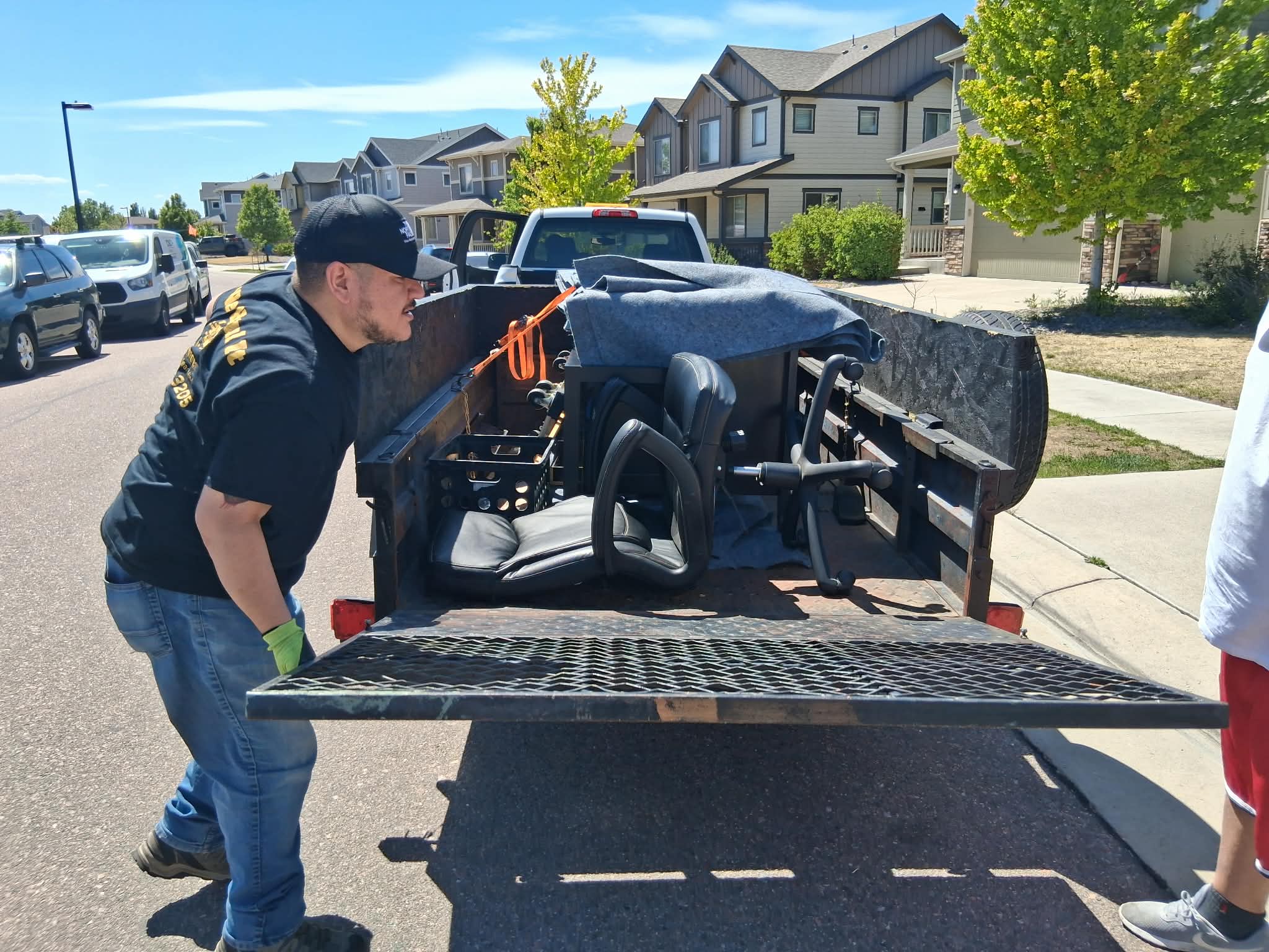 The We Haul It crew loading a trailer in a Denver neighborhood